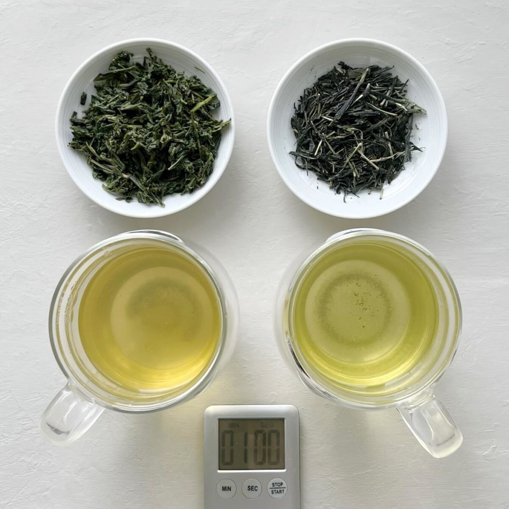 Overhead shot of dry and wet green tea, with two cups of green tea brewed at different temperatures